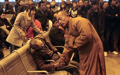 僧人拉住死者的手，向亡灵和在场所有活着的人传递佛陀的大爱和人间的温暖